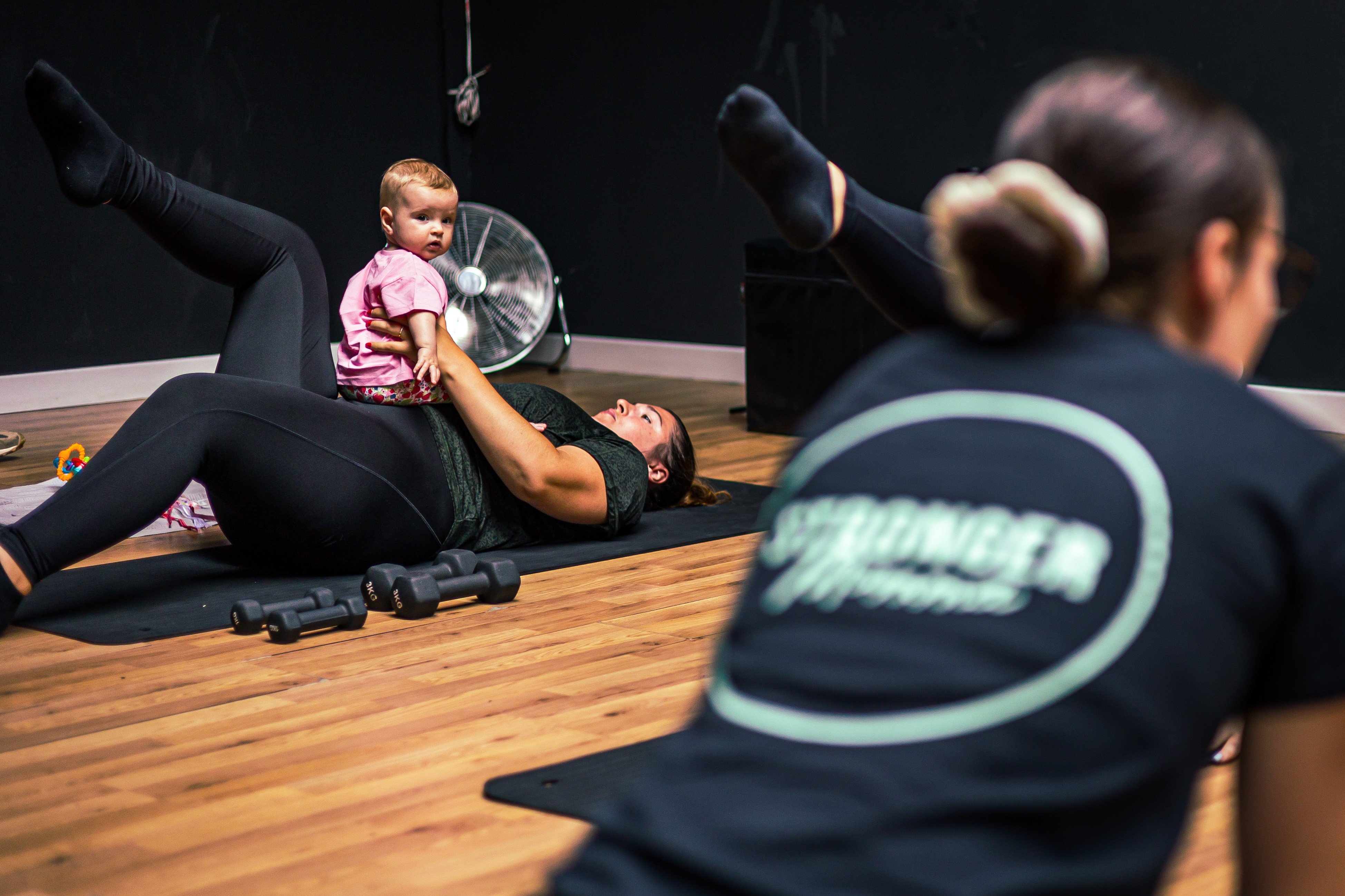 a fitness instructor interacts with a young baby